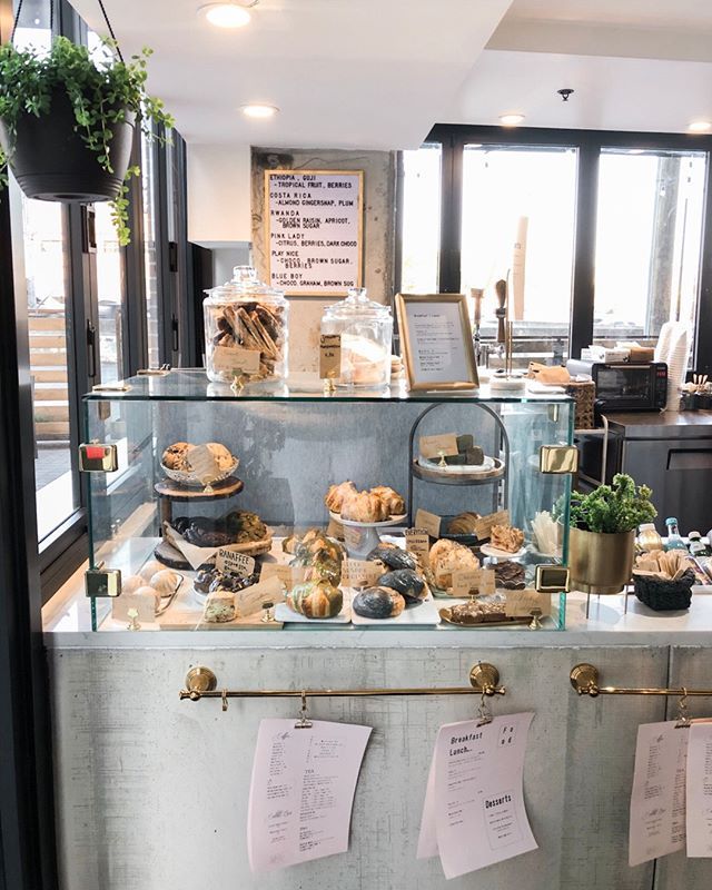 a display case filled with lots of different types of breads and pastries in front of windows