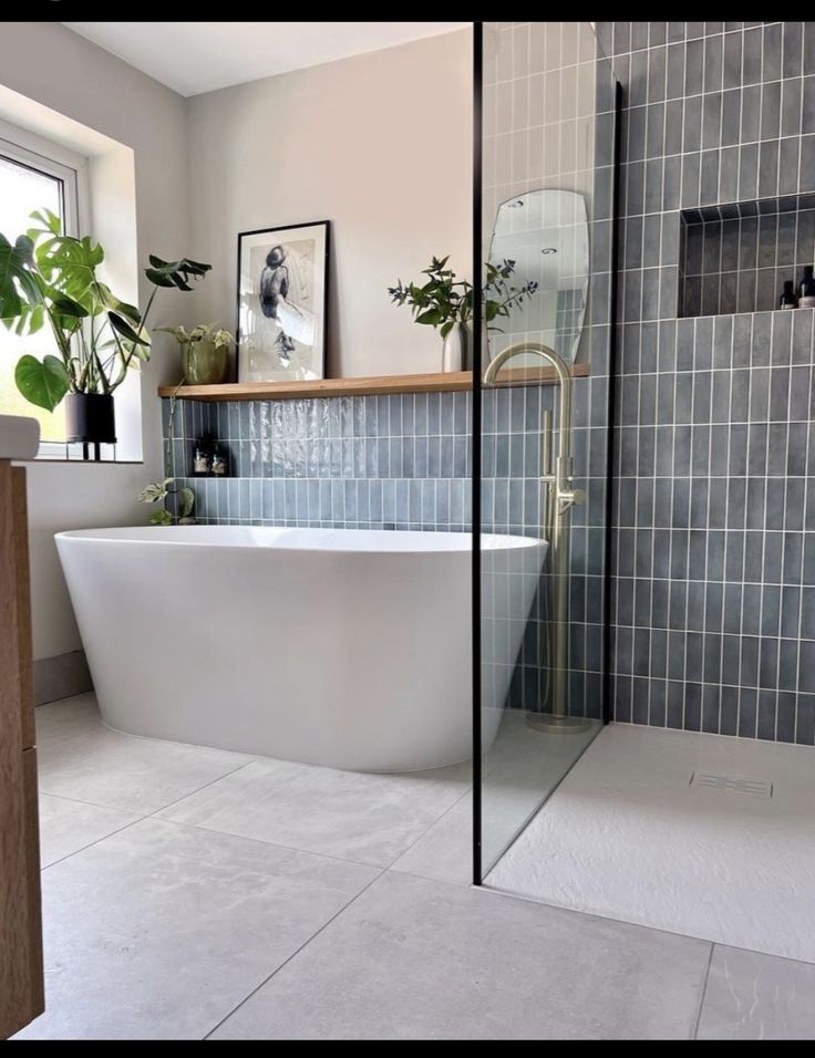 a white bath tub sitting inside of a bathroom next to a window