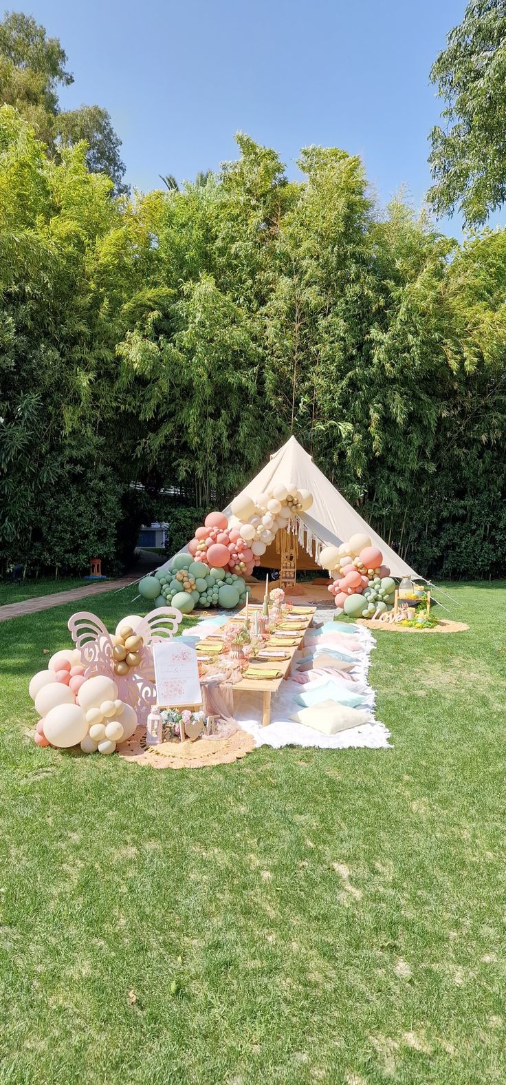 a tent set up in the middle of a field with food and drinks on it