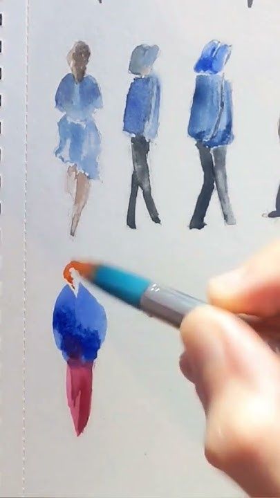 a person is holding a pencil and drawing people on paper with watercolors in front of them