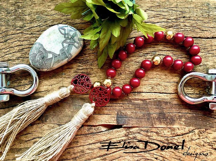 red beads and tassels are arranged on a wooden surface