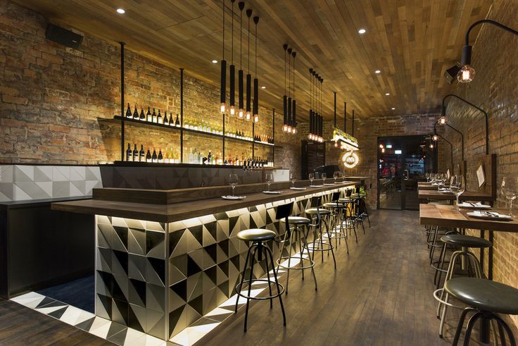 an empty bar with stools and wooden walls