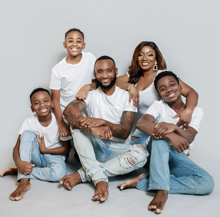 a group of people sitting next to each other posing for a photo with their arms around one another