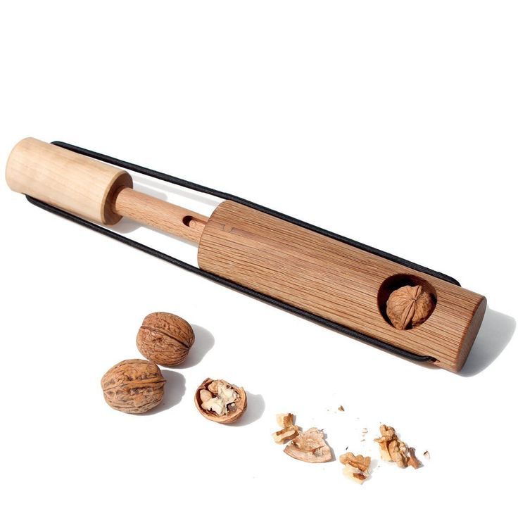 a wooden spoon and some nuts on a white surface