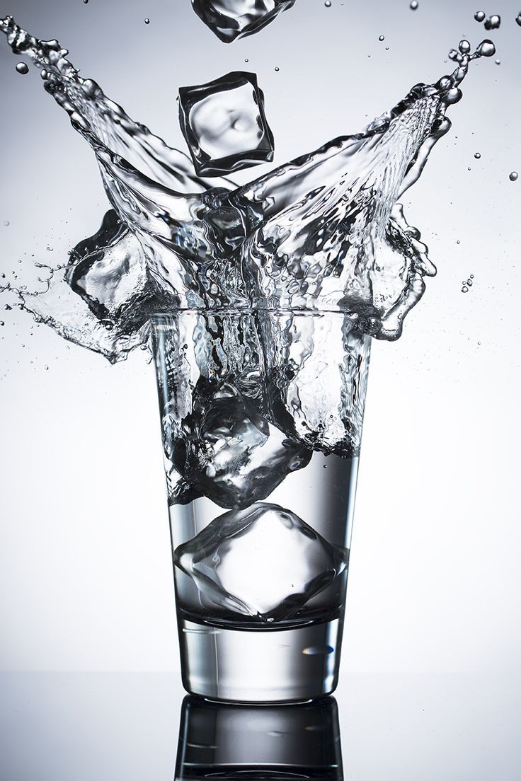 water splashing into a glass with ice cubes