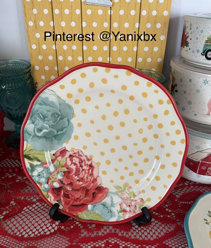 there is a plate with flowers on it next to other plates and containers in the background