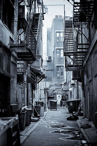 an alleyway in the city with fire escapes