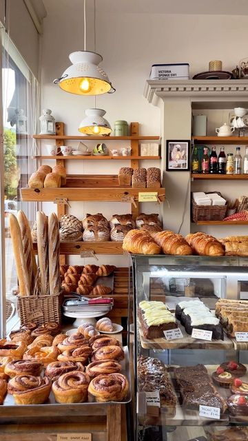 a bakery filled with lots of different types of breads and pastries on display