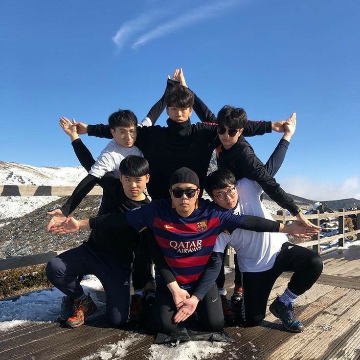 a group of young men standing next to each other on top of a snow covered ground