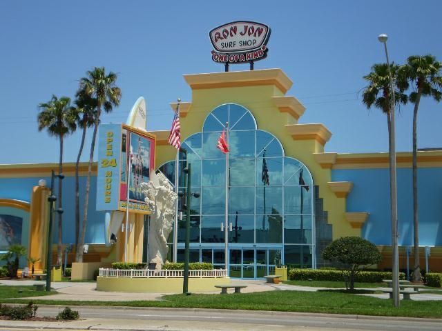 a building with palm trees in front of it and an american flag on the roof