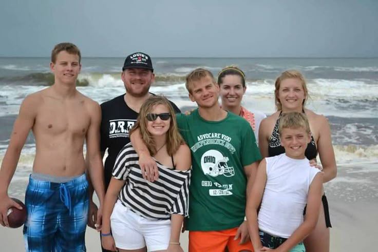 a group of people standing next to each other on a beach