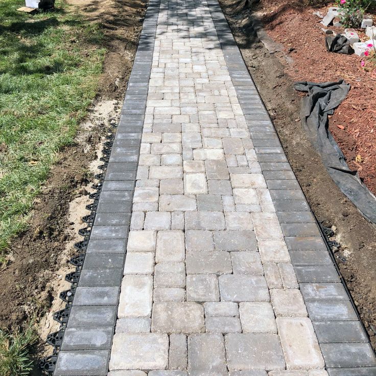 a brick walkway in the middle of a garden