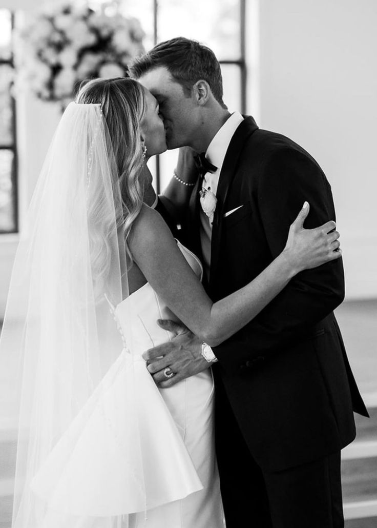 a bride and groom kissing each other in front of the alter at their wedding ceremony