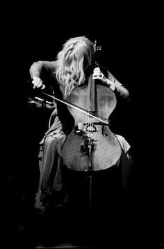 a woman sitting on top of a chair holding a violin