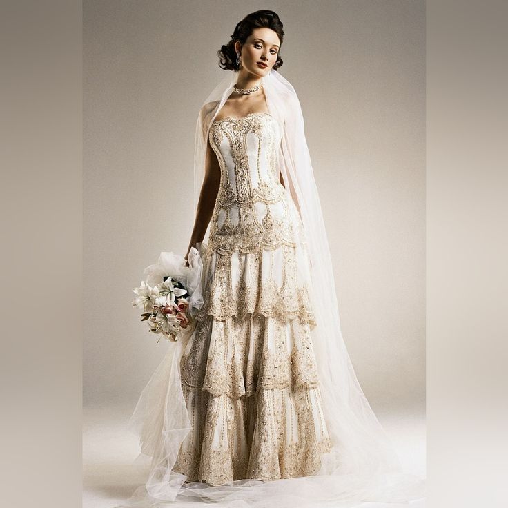 a woman in a wedding dress with a veil on her head and bouquet in her hand