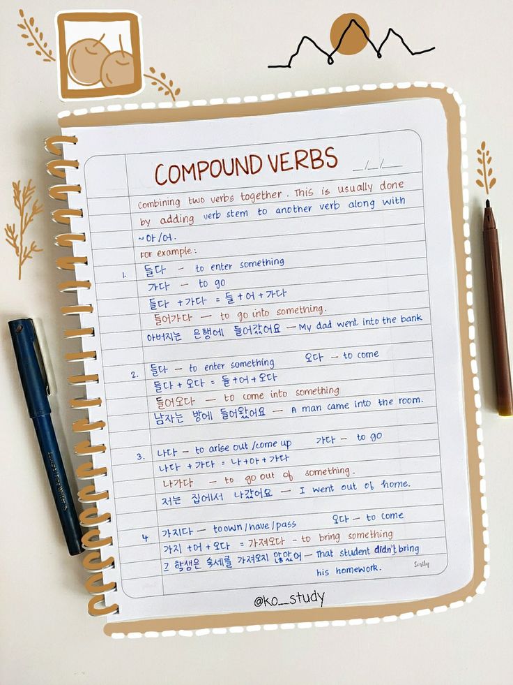 an open notebook with compound verbs written on it next to a pen and pencil