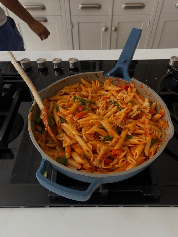 a pan filled with pasta sitting on top of a stove