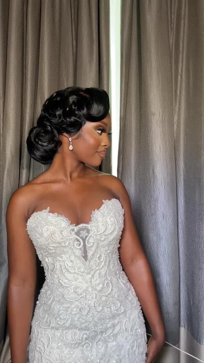 a woman in a wedding dress standing next to a curtain