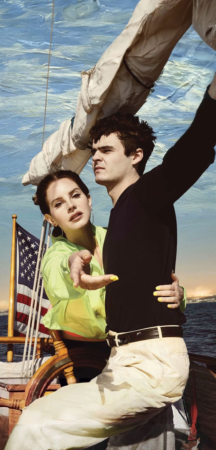 a man and woman on a boat with an american flag flying in the air behind them