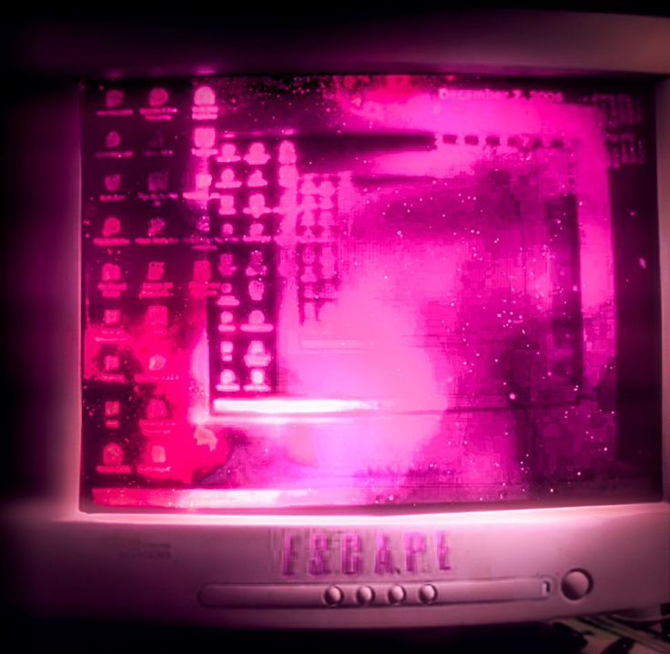 an old computer monitor with pink light on it