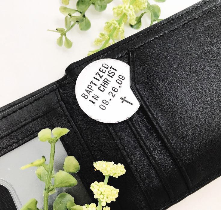 a black wallet with a white sticker on it and some flowers in the corner