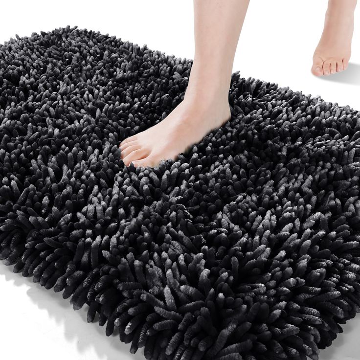 a person standing on top of a black rug with their feet in the floor and one foot sticking out