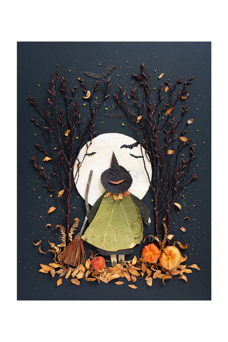 a paper plate with leaves, branches and a cat on it in front of a full moon