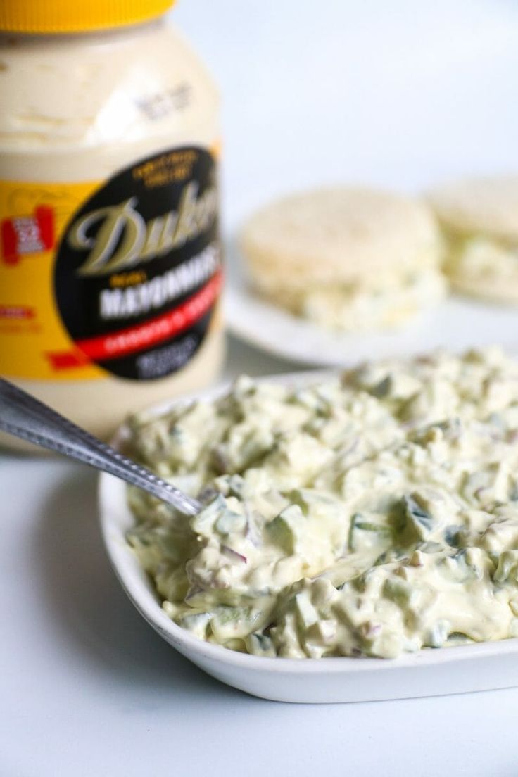 there is a bowl of food on the table next to crackers and mayonnaise