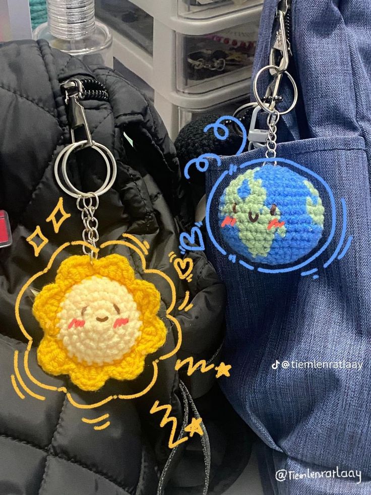 two crocheted keychains sitting next to each other on top of a bag