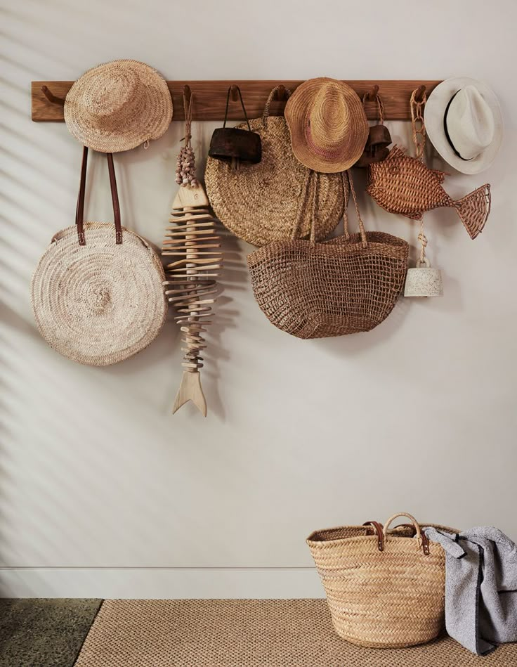 several hats are hanging on the wall with hooks and baskets in front of one another