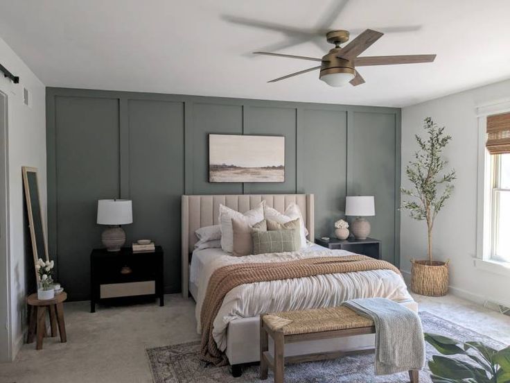 a bedroom with green walls and white bedding