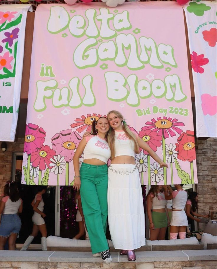 two women standing in front of a sign