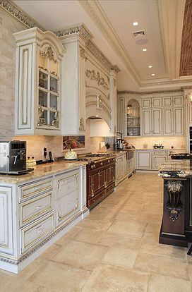 a large kitchen with white cabinets and marble counter tops