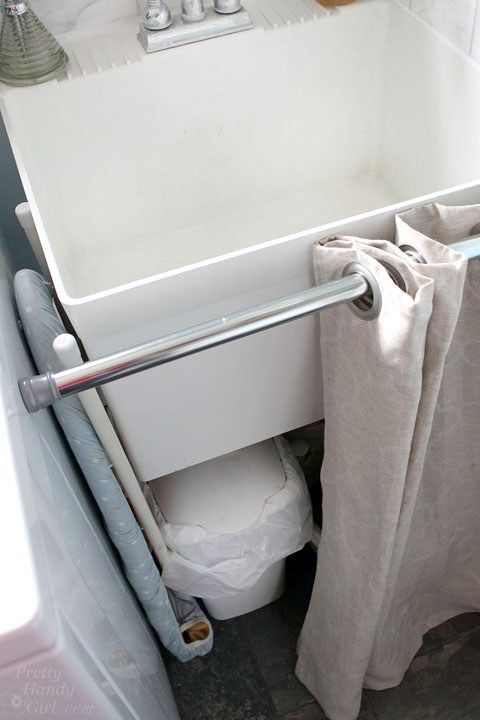 a white toilet sitting next to a bath tub under a bathroom sink with a towel hanging from it's side