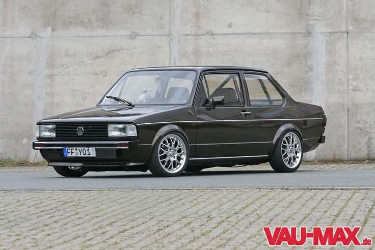 an old black car parked in front of a concrete wall with the words vau - max on it