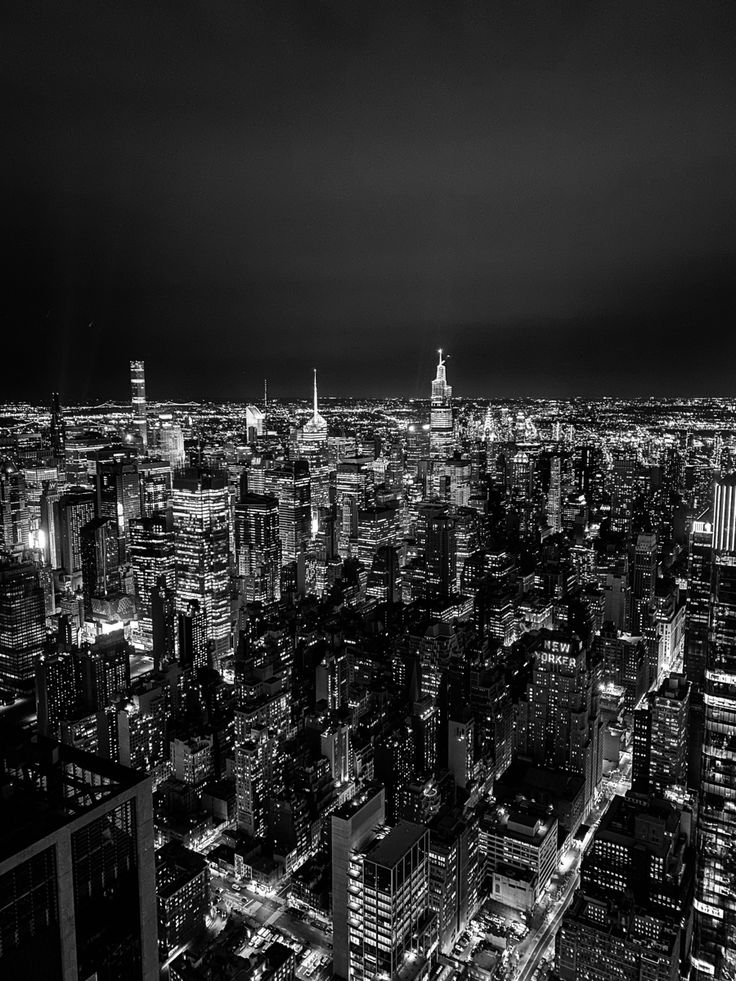 black and white photo of city lights at night from the top of a skyscraper building