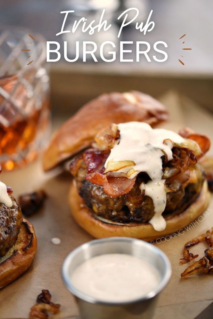 a beef patty on a pretzel bun topped with melted cheese, bacon slices, caramelized onions and sauce dripping down the sides with a metal ramekin of sauce and glass of whiskey in the background. Irish Lunch, Pub Burger Recipe, Pub Burgers, Irish Pub Food, Delicious Burger Recipes, Irish Dinner, Family Favorite Recipes, Irish Cooking, Hp Sauce