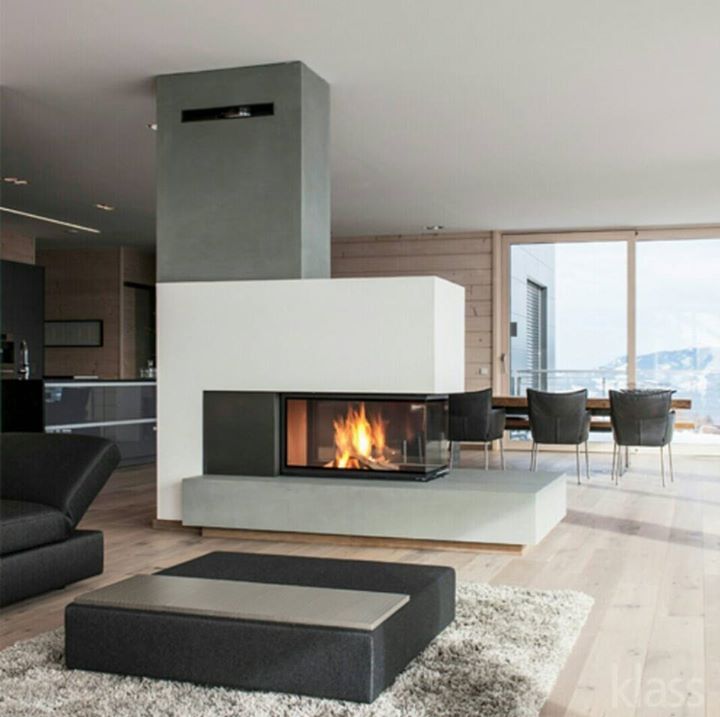 a living room filled with furniture and a fire place next to a dining table on top of a hard wood floor