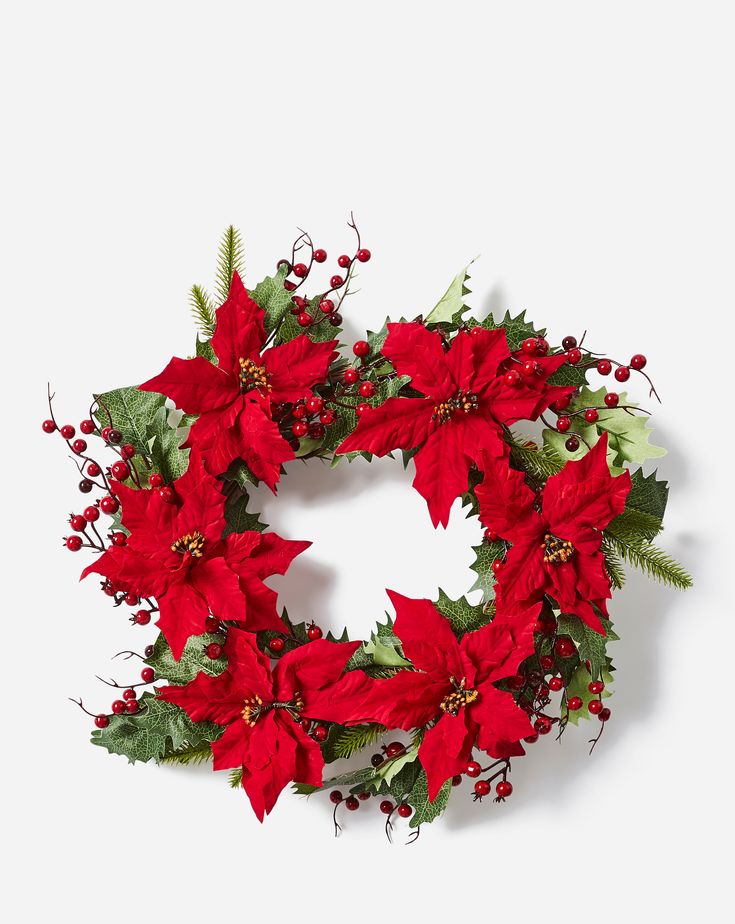 a christmas wreath with red poinsettis and greenery on a white background