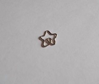 a star shaped metal object sitting on top of a white surface with the word love spelled in