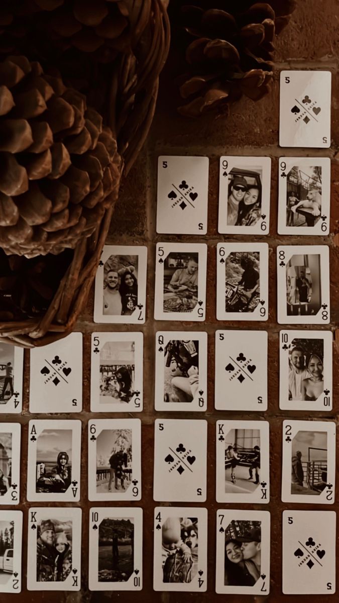 playing cards are laid out on the floor next to a pine cone and some cones