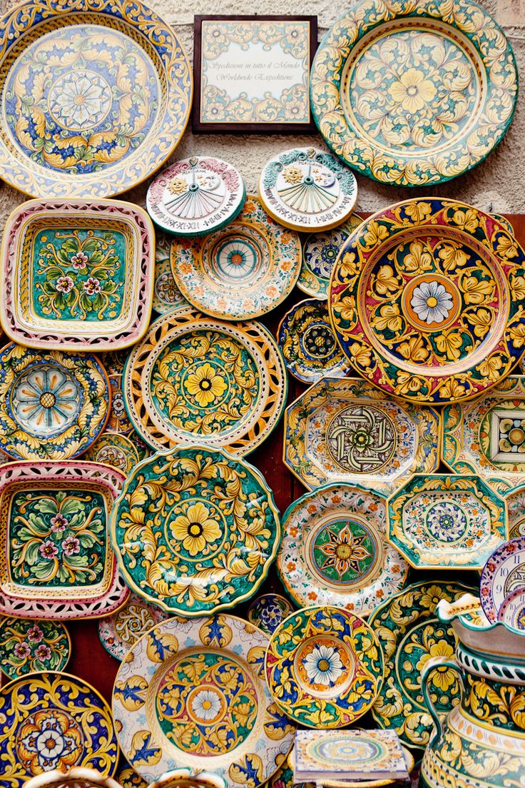 there are many colorful plates on display together