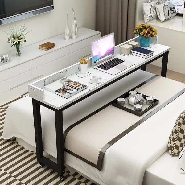 a laptop computer sitting on top of a white table in a living room next to a window