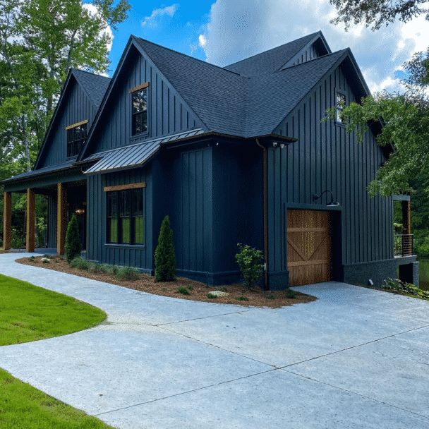 a large house with blue siding and green trees