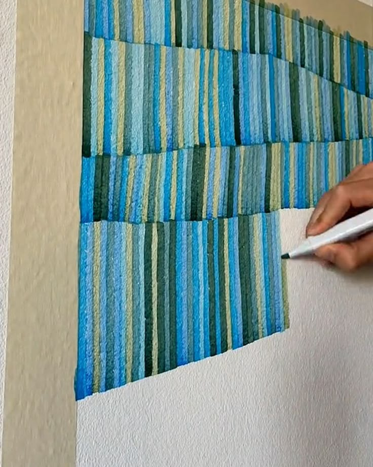 a person is using a pair of scissors to cut strips of fabric on the wall