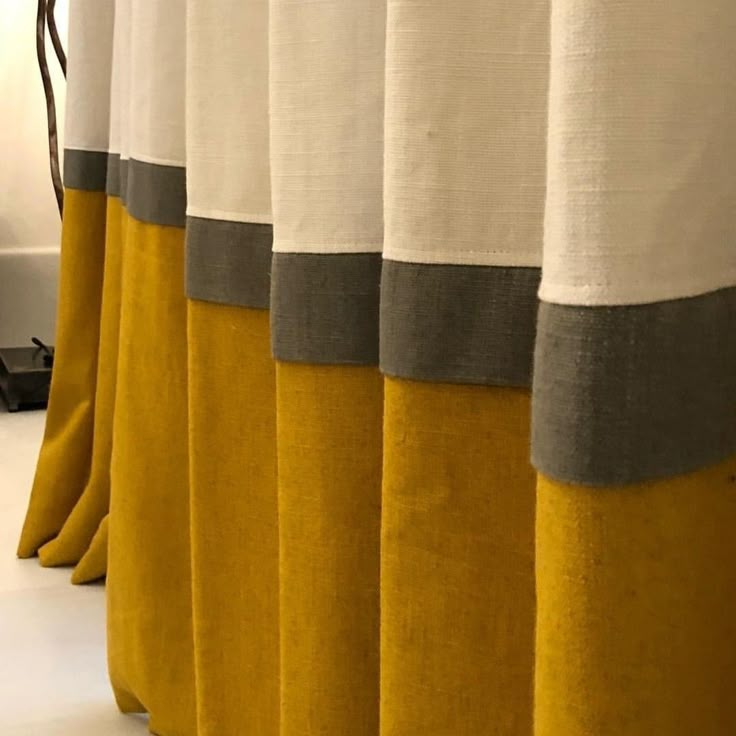 yellow and grey curtains are lined up in a row