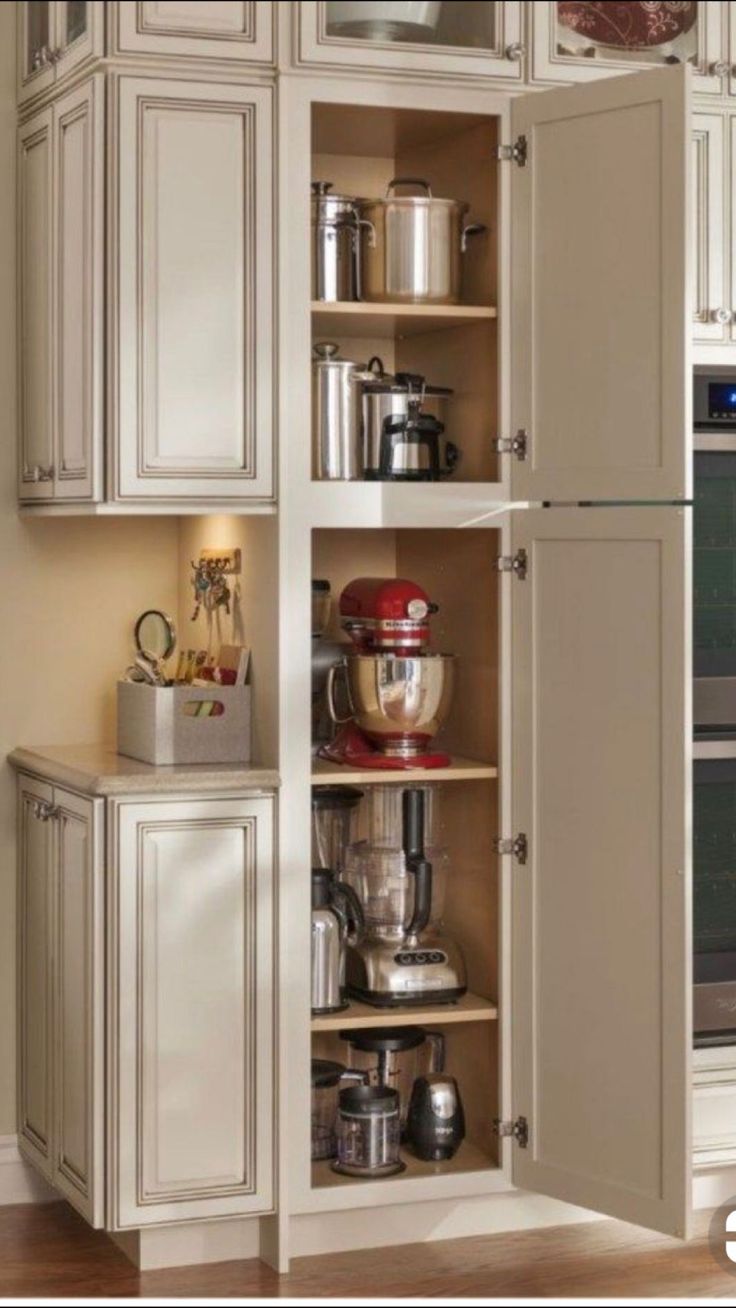 an open cabinet in a kitchen filled with appliances