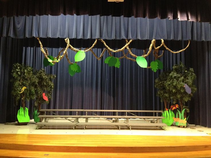 the stage is decorated with green plants and paper lanterns hanging from it's ceiling