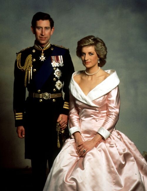 a man and woman in formal dress posing for a photo