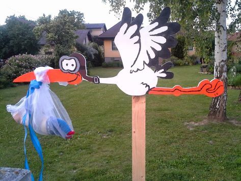 a wooden sign with a stork holding a bag on it's shoulder